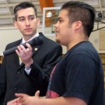 mmc 1 STHS student Jesus Herrera talks as Norman Gonzales hold microphone.