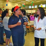 health Sylvia Hurtado, right, Barton’s Occupational Health Services assistant, provided vision screening at last year’s Latino Family Health Day. Photo/Provided