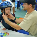 Jackson Trew, 5, has his helmet fitted by Pete Fink. Photos/Kathryn Reed