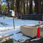 zc - 1 Locking toward the lodge from the lake, the round item at the bottom of the photo is where a hole was drilled, the concrete behind and to the left of the sign is an underground tank, and the fenced off area to the right is the sparge unit.