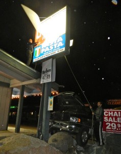 Keys Liquor workers on March 26 work to secure the sign. Photos/LTN