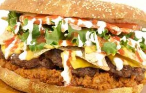 er: The Western Michigan Whitecaps fans bask in indulgence with their $20, 4,889-calorie, 4-pound specialty burger. It features five burgers (each weighs in at one third of a pound), topped with chili, cheese, chips, salsa, lettuce, and sour cream, all wedged between a giant sesame-seed bun. While you’re there, you might as well order a side of the fried Mac and Jack Cheese Bites.(Photo: Benjamin Hill)