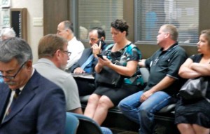 Ray Nutting, back left on phone, with wife, Jennifer, wait with supporters July 22, while his attorney, David Weiner, left foreground, goes over paperwork. Photo/Kathryn Reed