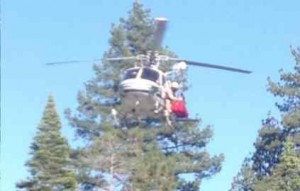 A CHP helicopter hoists an injured cyclist from Sugar Pine Point on July 6. Photo/CalFire