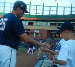 Aces rightfielder Brad Snyder signs autographs before the game.