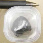 A piece of the meteorite, next to a pen for size perspective, that was found in the Sutter Mill area in April. Photo/LTN