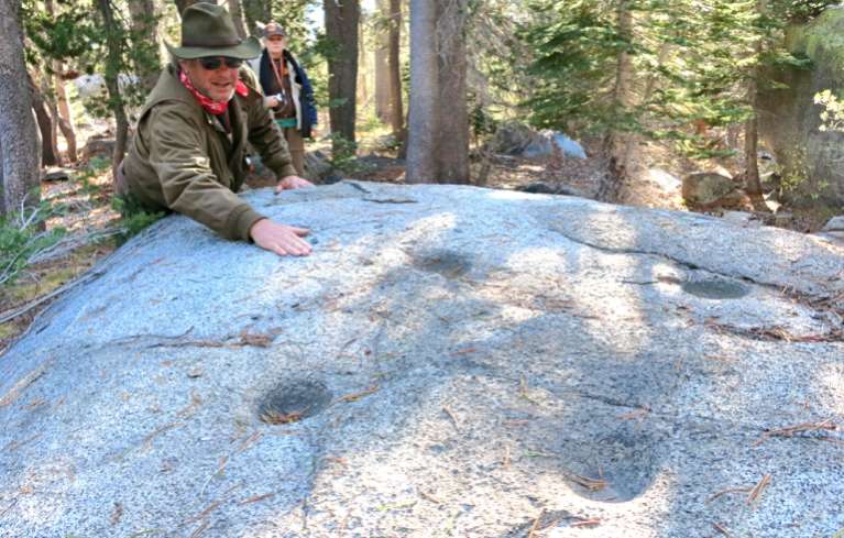 Guide Greg Zirbel points out the mortars on a granite boulder. Photos/Jessie Marchesseau