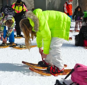 Emma Snipes tightens her snowshoe binding.