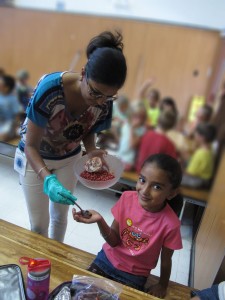 Ravinder Saini gives pomegranate seeds to her daughter, Arya. Photo/Provided