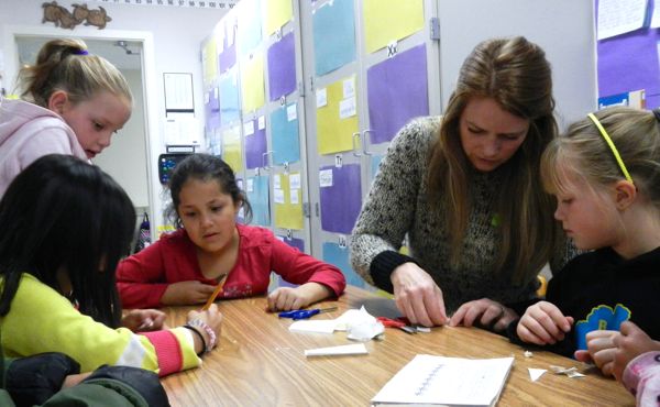 Katie Long shows students how to make snowflakes for Bijou's festival tree. Photos/Kathryn Reed