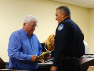 Police Chief Brian Uhler escorts Jim Morris away from the podium.