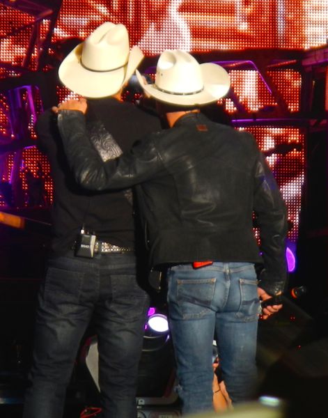 Brad Paisley and Justin Moore use a fan's phone to take a selfie.