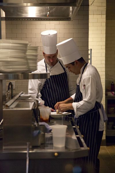Chefs Chris Watkins, left, and Nick Leandro prepare one of the six courses. Photo/Carolyn E. Wright/Copyright
