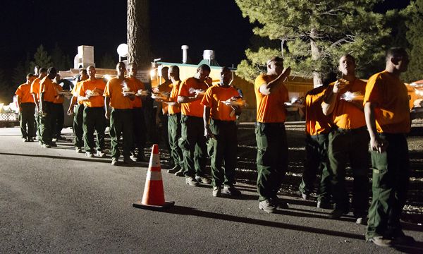 Inmates, temporarily calling Turtle Rock Park home, get dinner June 25 after working the fire line. Photo/Carolyn E. Wright/Copyright
