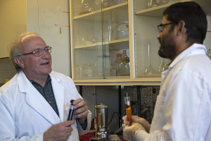 Glenn Miller and Bishnu Neupane holding the final biofuel product based on the gumweed plant. The fluids in the tubes have been diluted at different levels and are being examined in the labs at the Applied research Facility at the University of Nevada main campus. Photo by Whip Villarreal