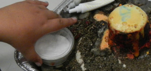 Yarelly Hernandez uses baking soda to make her volcano erupt.
