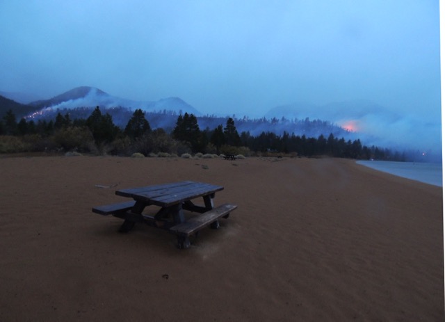 From the vantage point of Baldwin Beach, hot spots continued on the western and eastern sides of Cascade Ridge, though large flare ups appeared to be diminishing as rainfall continued about 7:30am. Photo/Taylor Flynn/Tahoe Mountain News